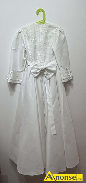 sukienka  do komunii opis dodatkowy: Sprzedam sukienk� komunijn�
Sukienka jest satynowa, u�ywana w bardzo dobrym stanie, elegancka, skromna, nowoczesna i bardzo efektowna, obw�d pasa 62cm, d�ugo�� od ramienia (przy szyi) do do�u sukienki 115cm
Klasyczna konstrukcja, d� sukienki rozszerzany ku do�owi, pod sp�dnic� jest halka, wszyta na sta�e z warstw� sztywnego tiulu, kt�ry unosi sukienk�.
R�kawy 3/4 rozszerzane na dole, z delikatn� falbank�. W pasie satynowy paseczek z kokard� z ty�u (kt�ra jest opcjonalna), z przodu na klatce piersiowej naszyta jest aplikacja koronkowa.
Z ty�u wszyty jest kryty zamek. Sukienka d�uga zakrywaj�ca buta. Do sukienki do��czona jest torebeczka z materia�u, eleganckie r�kawiczki, wianuszek i narzutka na ramiona.
 - image 1